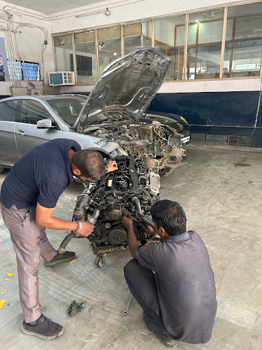 car repair worker performing repair work engine 2