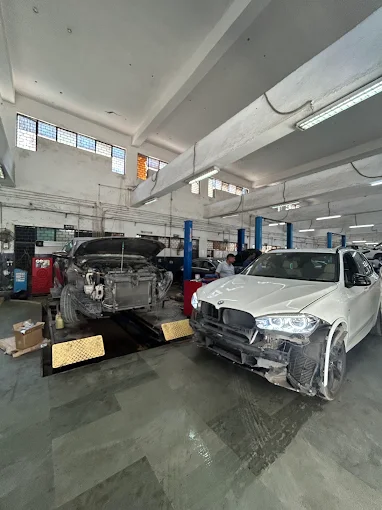 BMW vehicles under repair with front body work and inspection at XL Car Care workshop in Delhi NCR